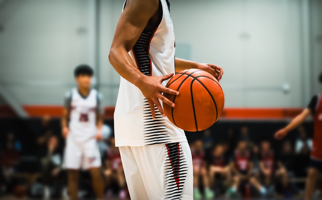 a basketball player in a white uniform holding a basketball.