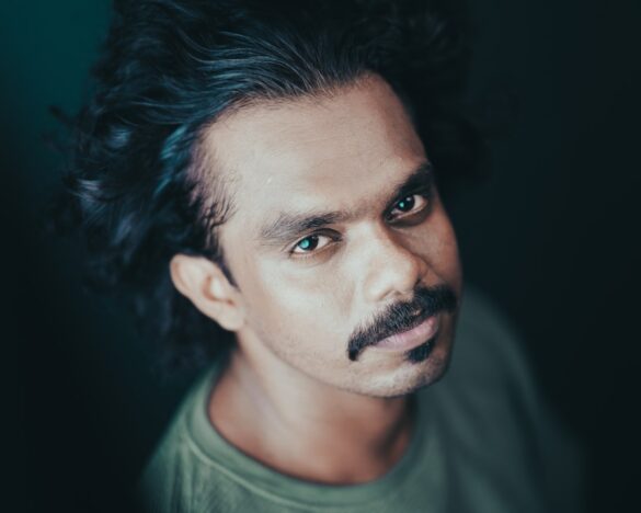 Man in a green round neck t-shirt looking at the camera