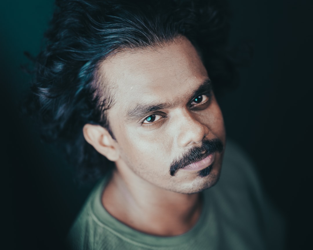 Man in a green round neck t-shirt looking at the camera