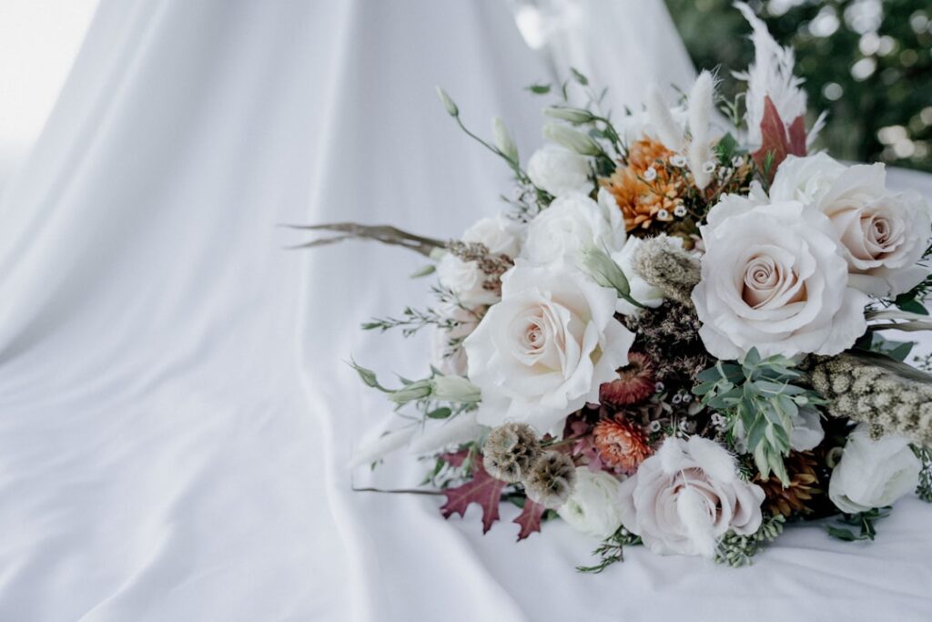 Brides bouquet lays on her dress.